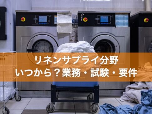 業務用洗濯機の前に置かれた白いシーツのカート